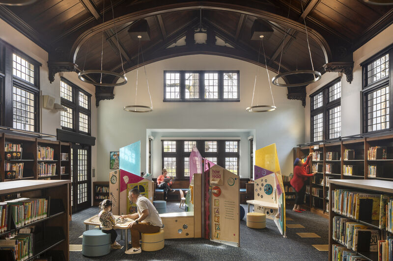 Midland Library renovated interior with restored barrel-vaulted dark-wood ceiling, tall arched windows, and chandeliers, Portland, Oregon